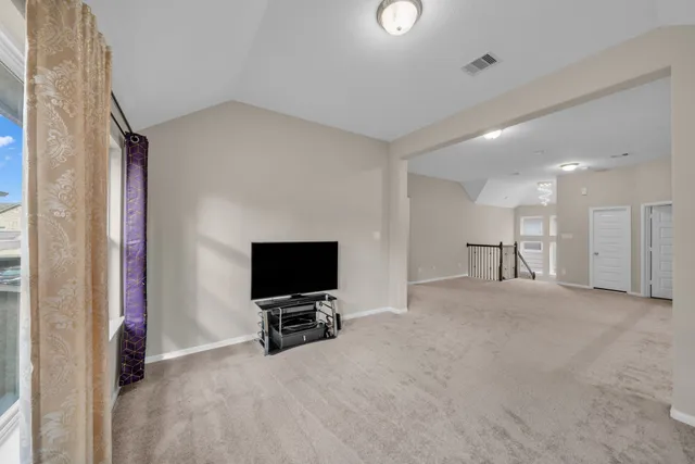 a view of a livingroom with a flat screen tv wooden floor and a cabinet