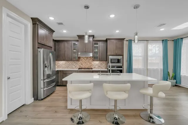 a large kitchen with a table and chairs