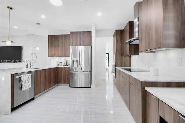 a kitchen with stainless steel appliances a refrigerator sink and stove