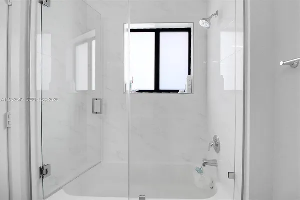 a living room with furniture a flat screen tv and floor to ceiling window