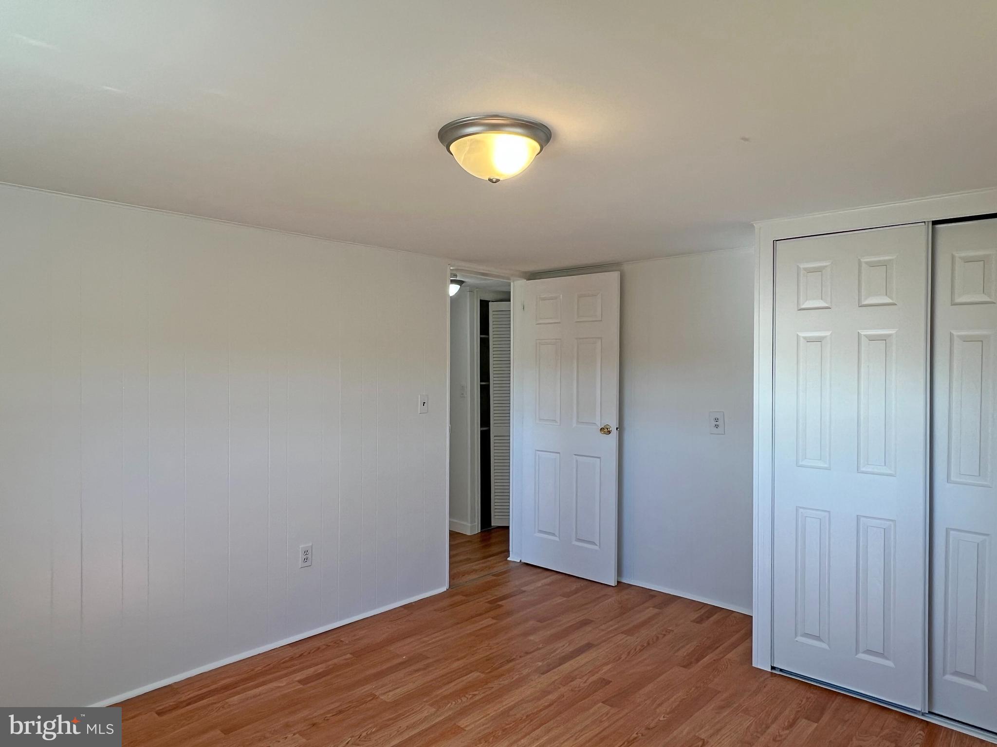 31658 Siham Road, Unit E42 Lewes, DE 19958 - Photo 20 of 35 a view of an empty room with wooden floor and closet