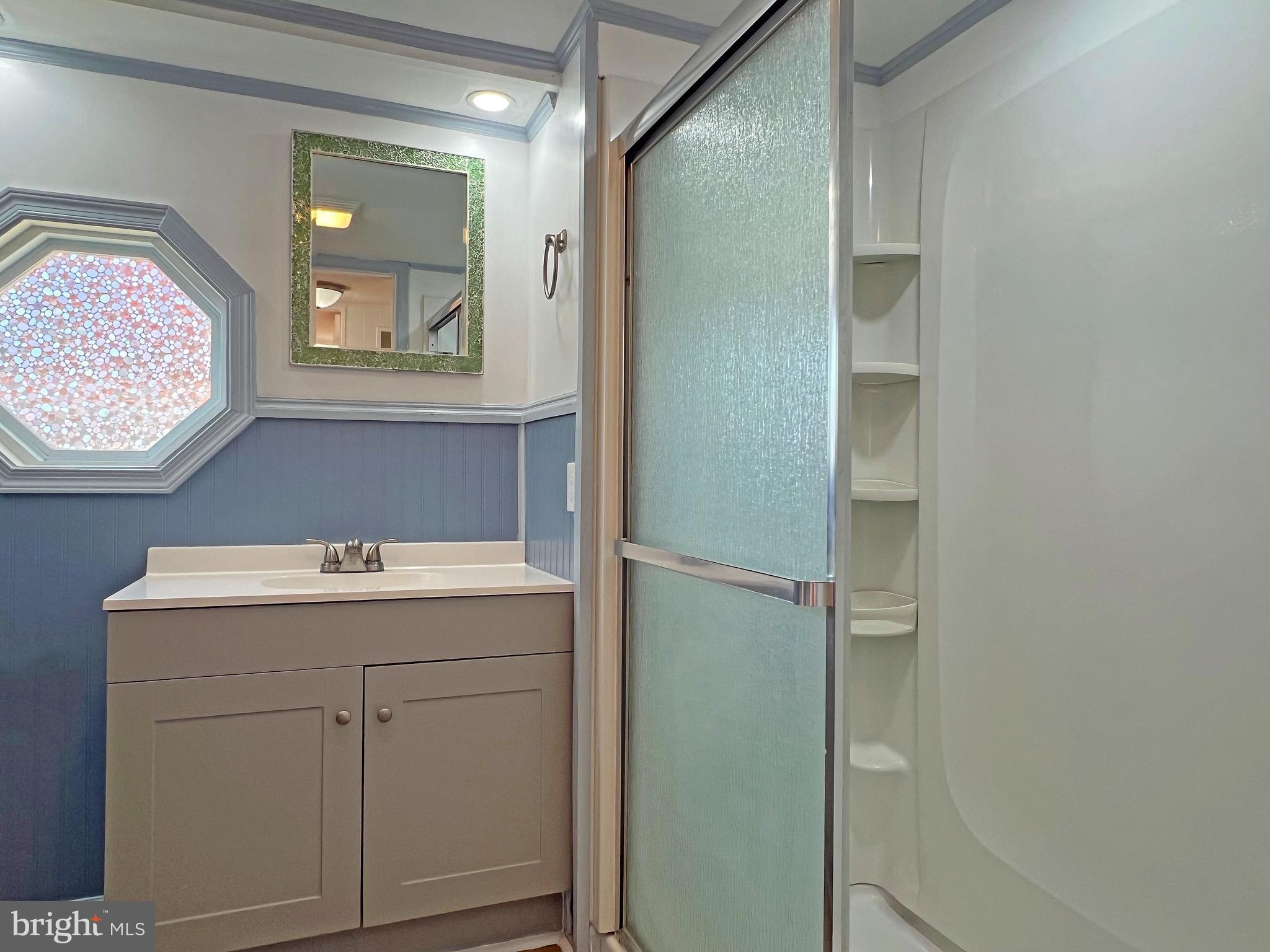 31658 Siham Road, Unit E42 Lewes, DE 19958 - Photo 23 of 35 a bathroom with a sink mirror and vanity