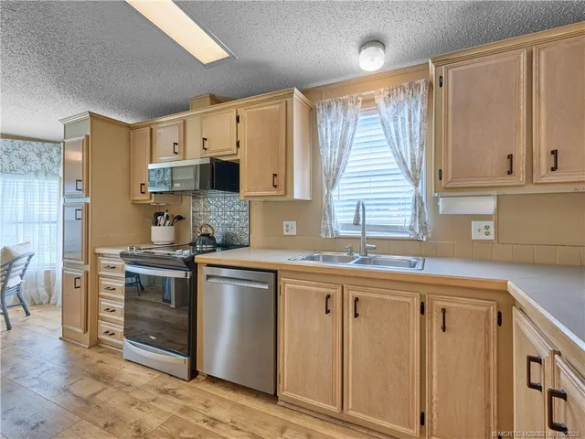 a kitchen with a refrigerator a sink and cabinets