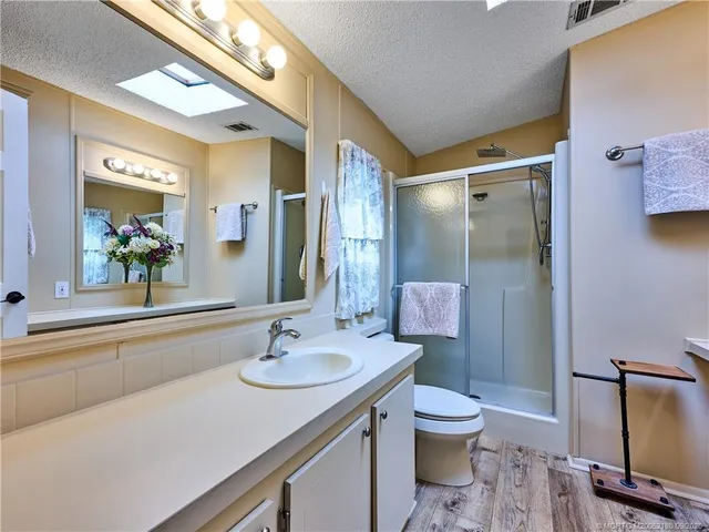 a view of bathroom with a sink mirror and window