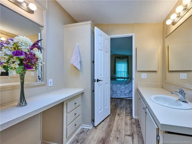 a view of a hallway to room with wooden floor and bedroom view