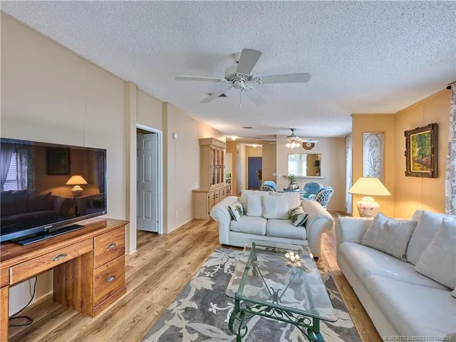 a large living room with furniture a chandelier and a large window
