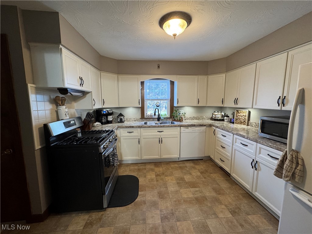 5322 Lockwood Road Madison, OH 44057 - Photo 11 of 30 Kitchen featuring appliances, plenty of counter space and white cabinetry
