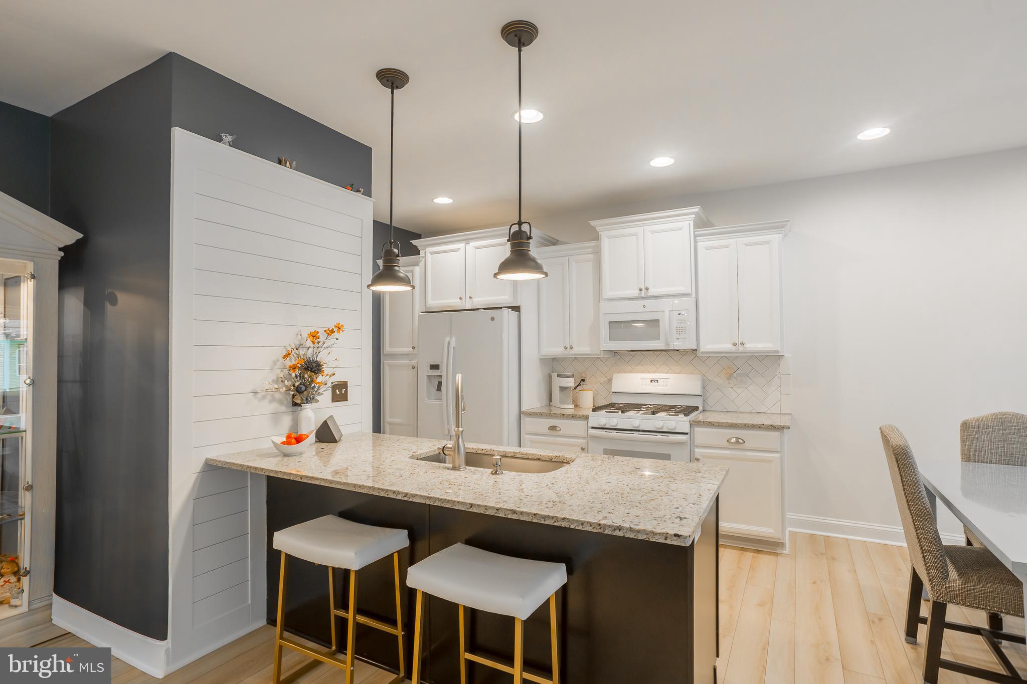 18308 Emerson Way Georgetown, DE 19947 - Photo 15 of 43 a kitchen with kitchen island cabinets dining table and chairs