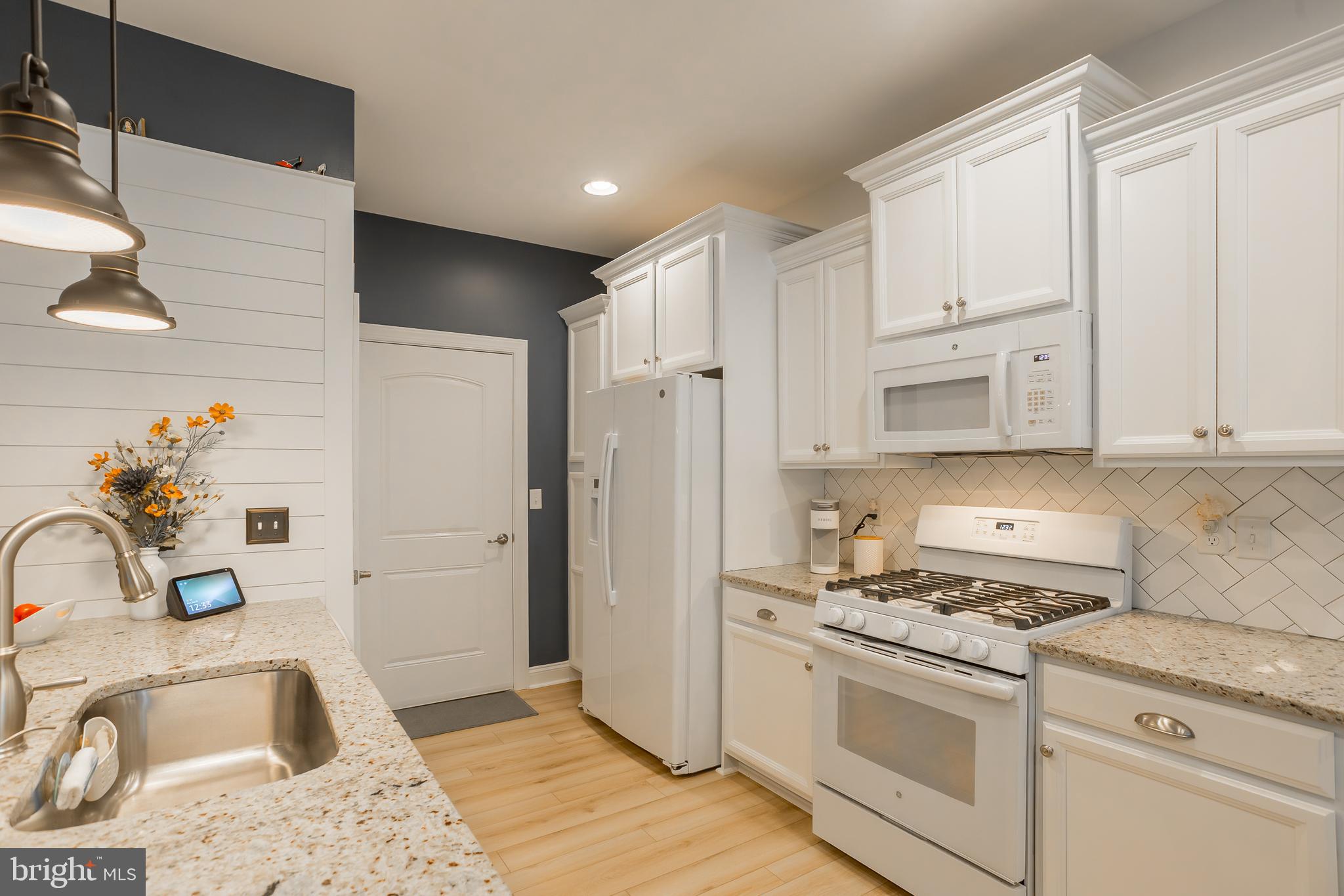 18308 Emerson Way Georgetown, DE 19947 - Photo 16 of 43 a kitchen with granite countertop a sink stove and refrigerator