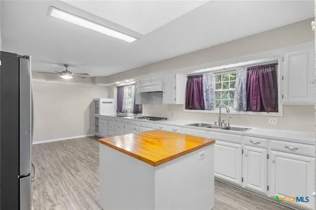 a view of a kitchen with a sink and dishwasher with wooden floor
