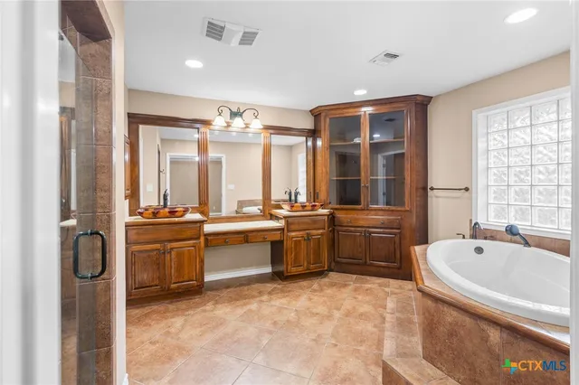 a large bathroom with a large tub and sink