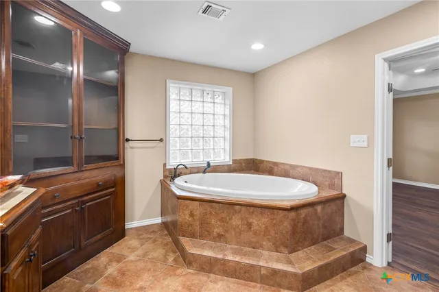 a spacious bathroom with a sink and a mirror