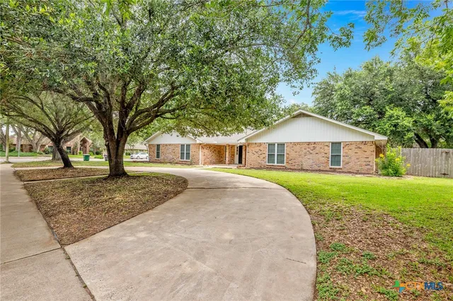 a front view of a house with a yard and trees