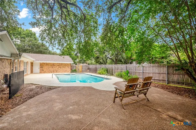 a swimming pool with outdoor seating and yard