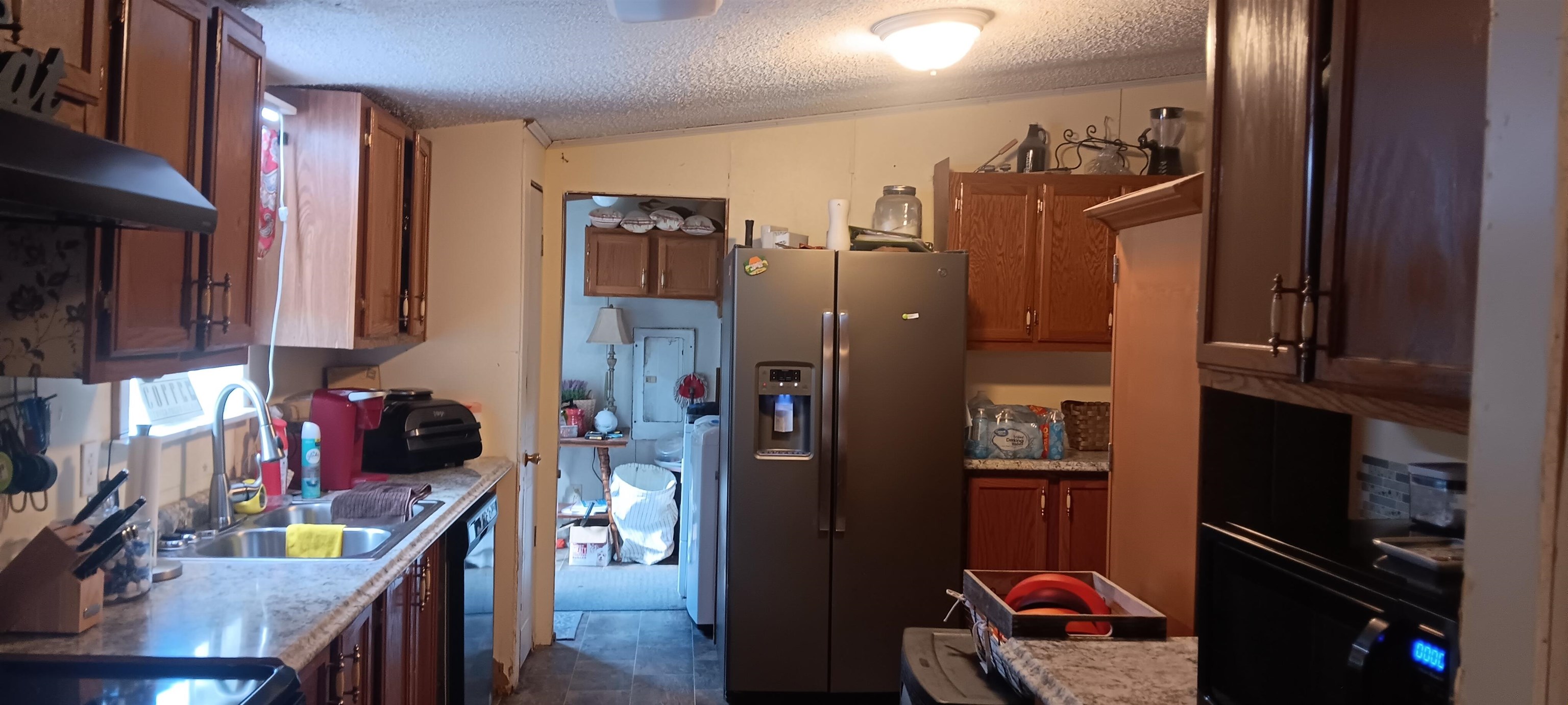 100 Academy Road Pulaski, TN 38478 - Photo 15 of 36 Kitchen featuring stainless steel refrigerator with ice dispenser, brown cabinetry, a textured ceiling, under cabinet range hood, and dishwasher