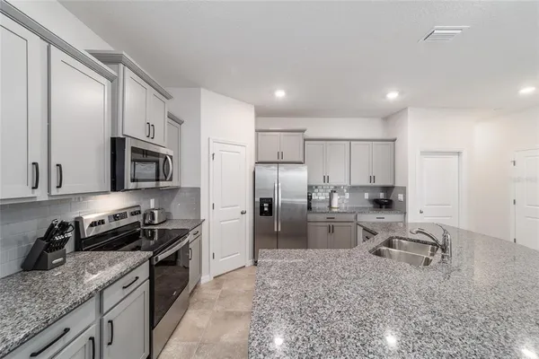 a kitchen with stainless steel appliances granite countertop a sink refrigerator and cabinets