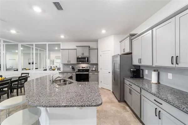 a kitchen with stainless steel appliances granite countertop a sink refrigerator and cabinets