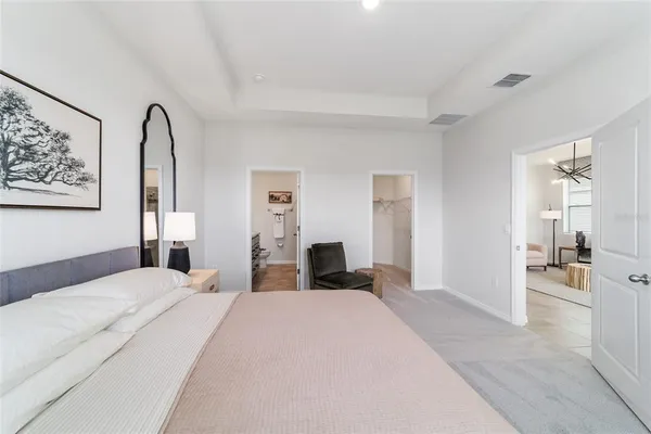 a bedroom with a large bed and a chandelier