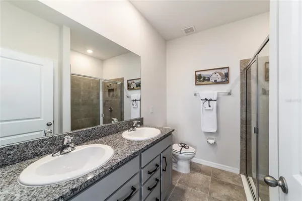 a bathroom with a granite countertop sink toilet and shower