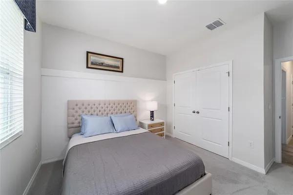 a bedroom with a bed and painting on the wall