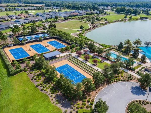 an aerial view of residential houses with outdoor space and lake view