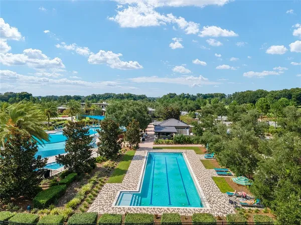 a view of swimming pool in front of residential houses with outdoor space