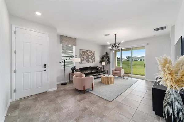 a living room with furniture a chandelier and a window
