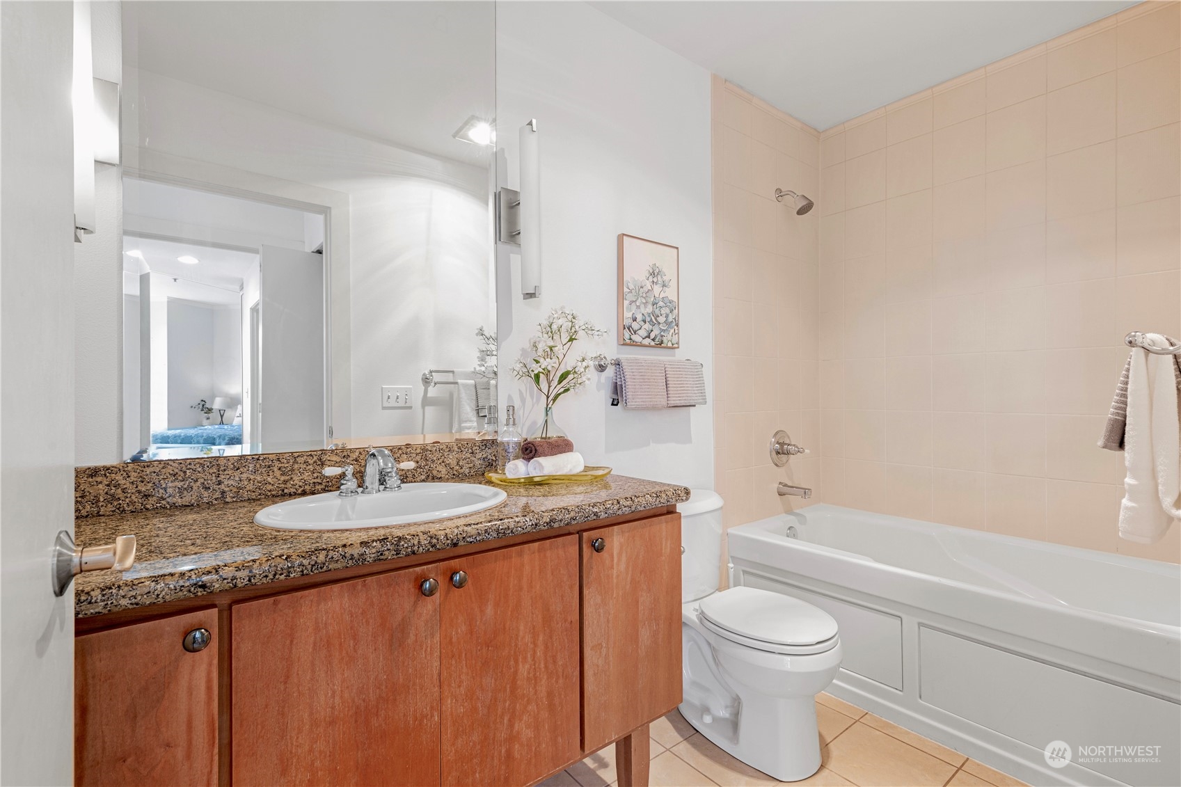 5000 30th Avenue Northeast, Unit 302 Seattle, WA 98105 - Photo 15 of 21 a bathroom with a granite countertop sink a toilet a mirror and bathtub