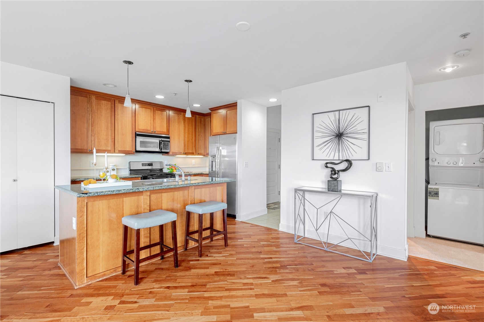 5000 30th Avenue Northeast, Unit 302 Seattle, WA 98105 - Photo 8 of 21 a kitchen with stainless steel appliances granite countertop a stove top oven a sink dishwasher and a refrigerator with wooden floor