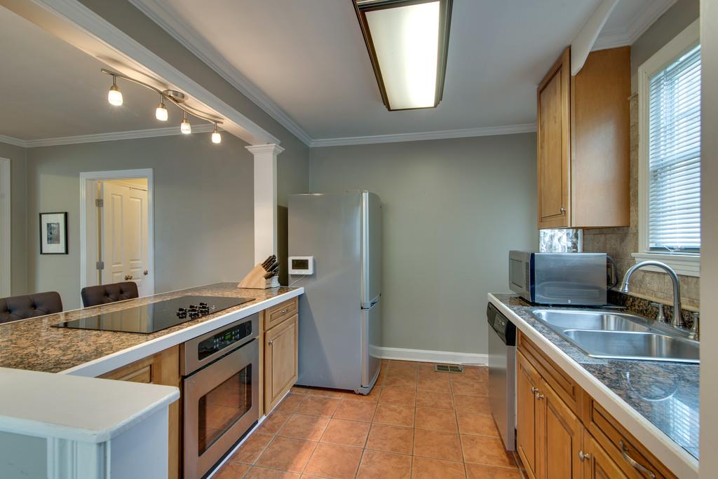5561 Knob Road Nashville, TN 37209 - Photo 11 of 26 a kitchen with stainless steel appliances granite countertop a sink stove and cabinets