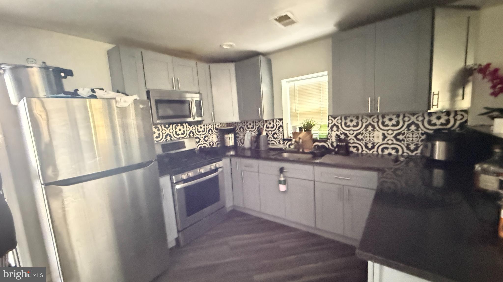 5129 Wakefield Street Philadelphia, PA 19144 - Photo 4 of 17 a kitchen with stainless steel appliances granite countertop a refrigerator a stove a sink and a refrigerator