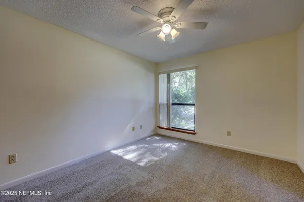 a view of empty room with chandelier fan