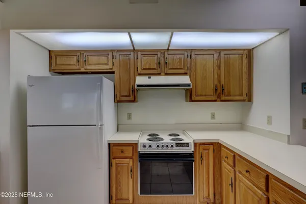 a kitchen with stainless steel appliances granite countertop a refrigerator a stove and a sink with wooden floor