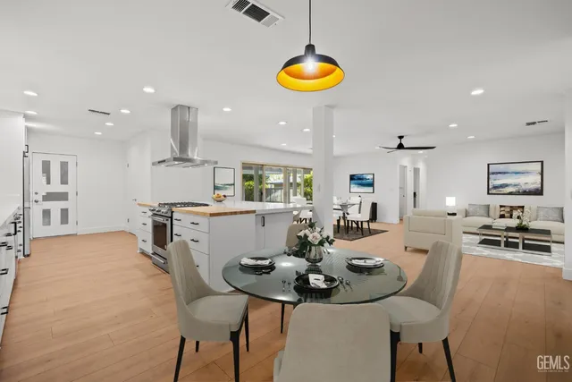 a kitchen with a stove a sink a window and white cabinets