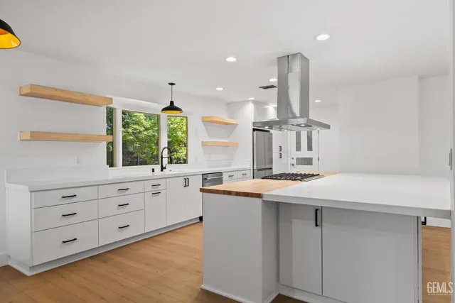 a kitchen that has a stove and a wooden floor