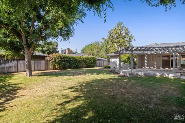 a view of an empty room with a window and kitchen view