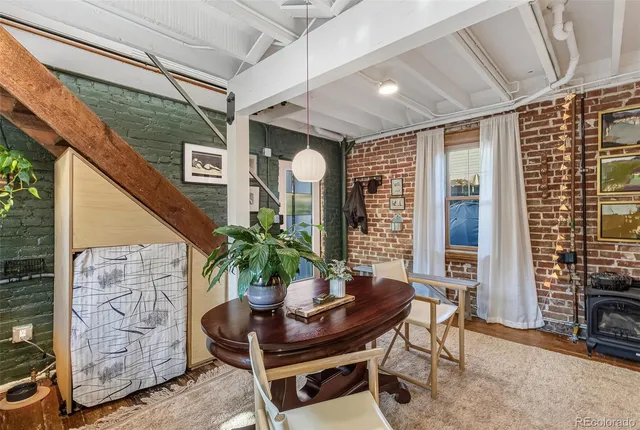 a living room with furniture a dining table and a potted plant