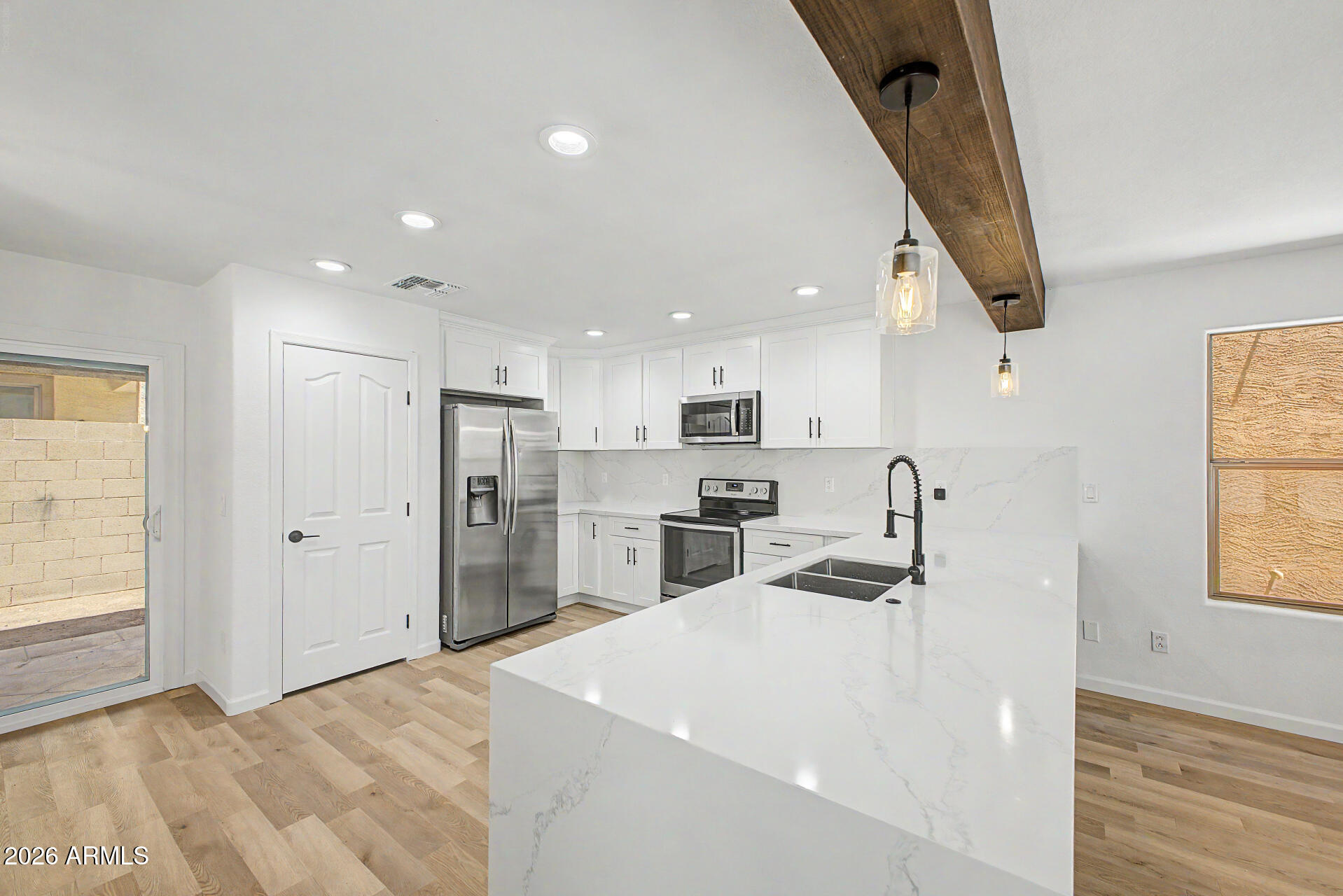 6452 West Ruth Avenue Glendale, AZ 85302 - Photo 13 of 35 a kitchen with stainless steel appliances kitchen island sink refrigerator and window