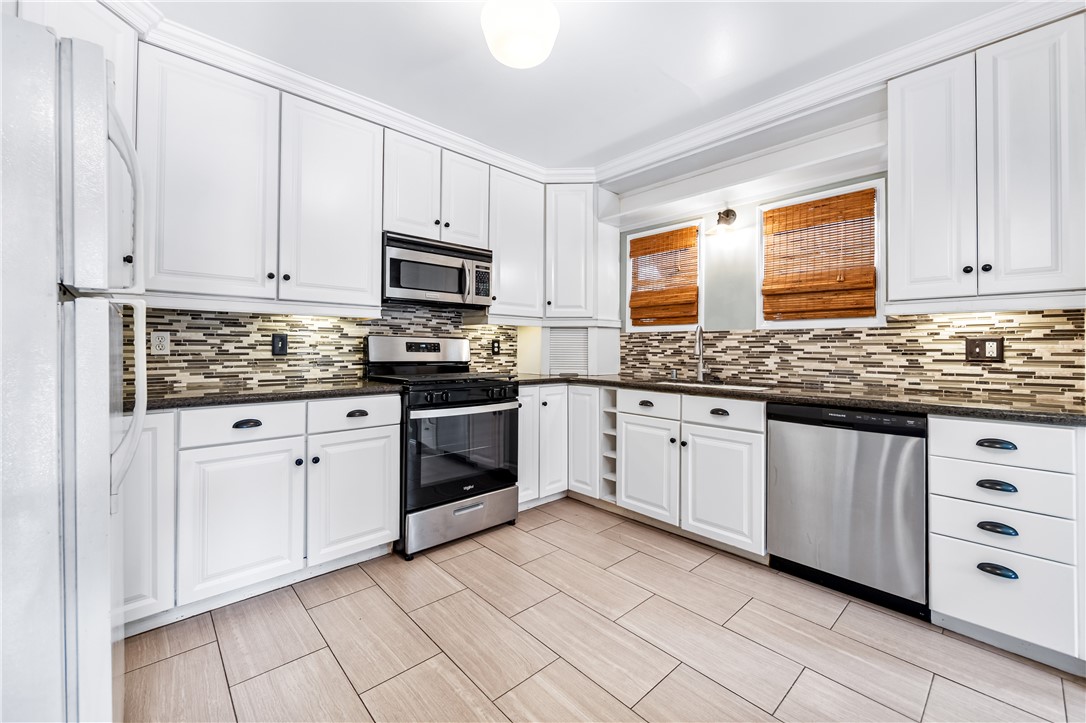 2109 Chestnut Avenue Long Beach, CA 90806 - Photo 13 of 32 a kitchen with granite countertop white cabinets sink and stainless steel appliances