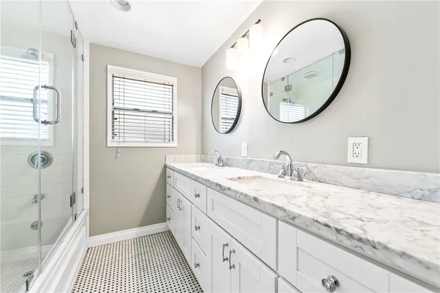 a bathroom with a granite countertop double vanity sinks and a mirror