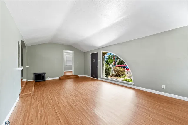 an empty room with wooden floor and a window