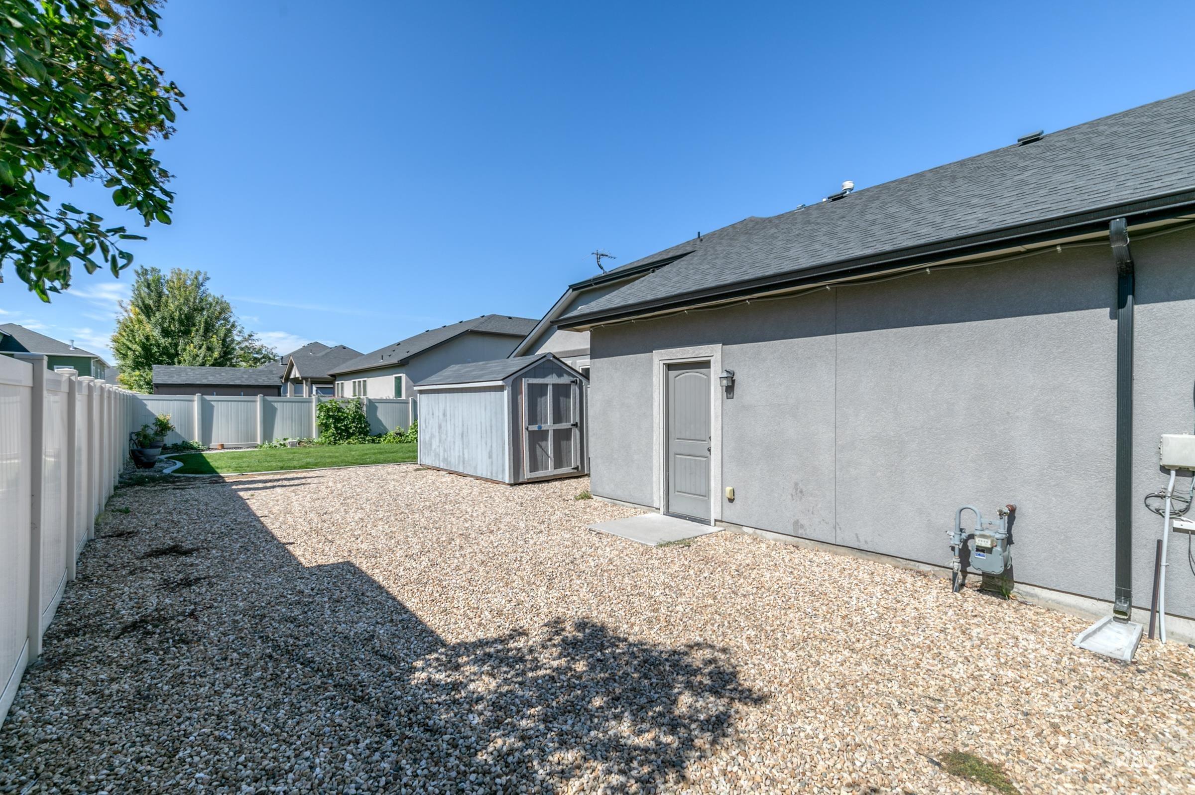 4316 Middlesboro Way Caldwell, ID 83607 - Photo 28 of 33 Spacious backyard with manicured lawn, covered patio, gravel area, and a utility shed