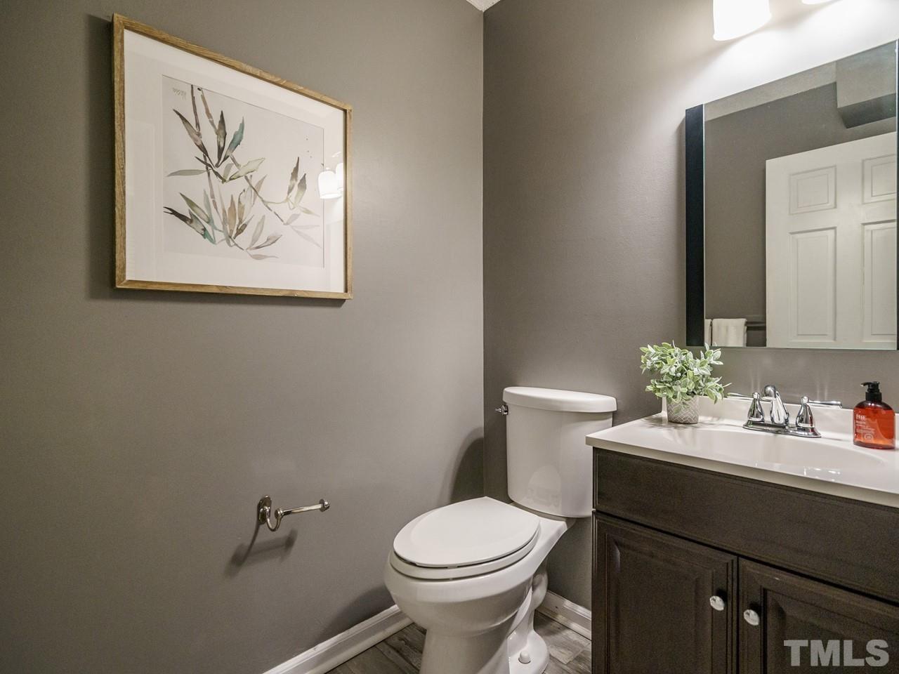 4109 Oak Park Road Raleigh, NC 27612 - Photo 11 of 28 a bathroom with a toilet a sink and mirror