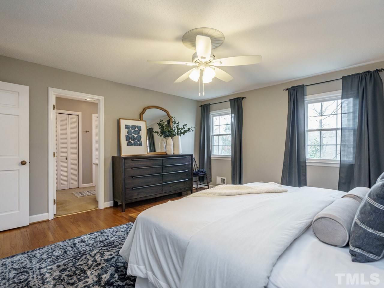 4109 Oak Park Road Raleigh, NC 27612 - Photo 14 of 28 a bedroom with a large bed and wooden floor