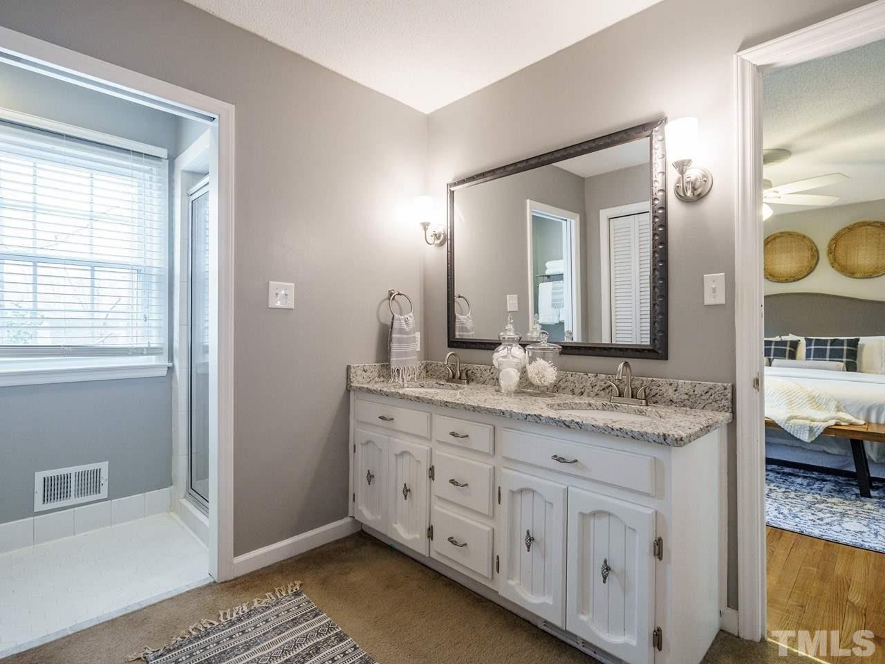4109 Oak Park Road Raleigh, NC 27612 - Photo 15 of 28 a en suite bathroom with a granite countertop sink and a mirror