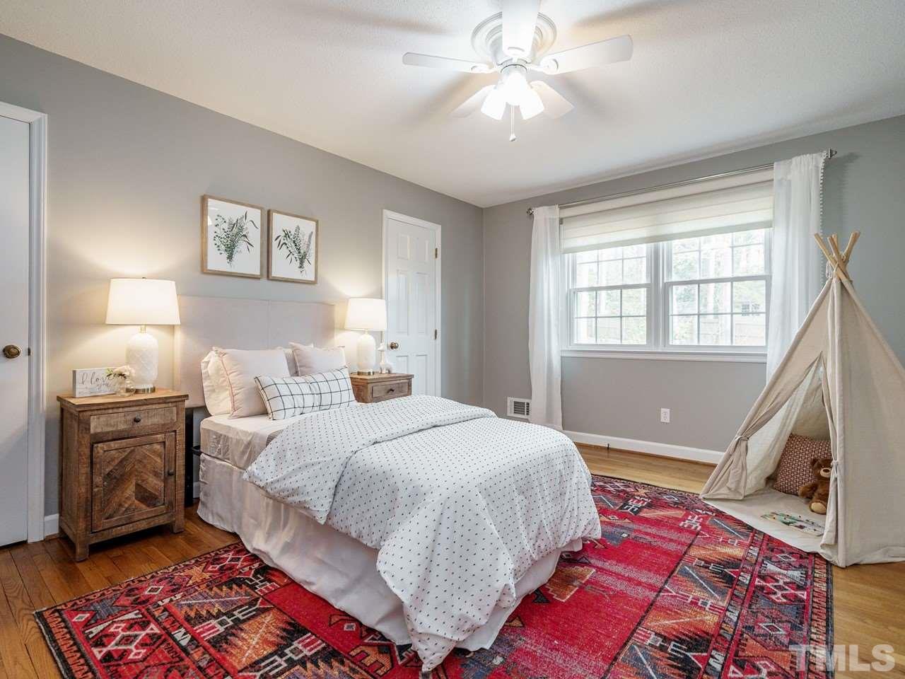 4109 Oak Park Road Raleigh, NC 27612 - Photo 17 of 28 a bedroom with a bed and a chandelier