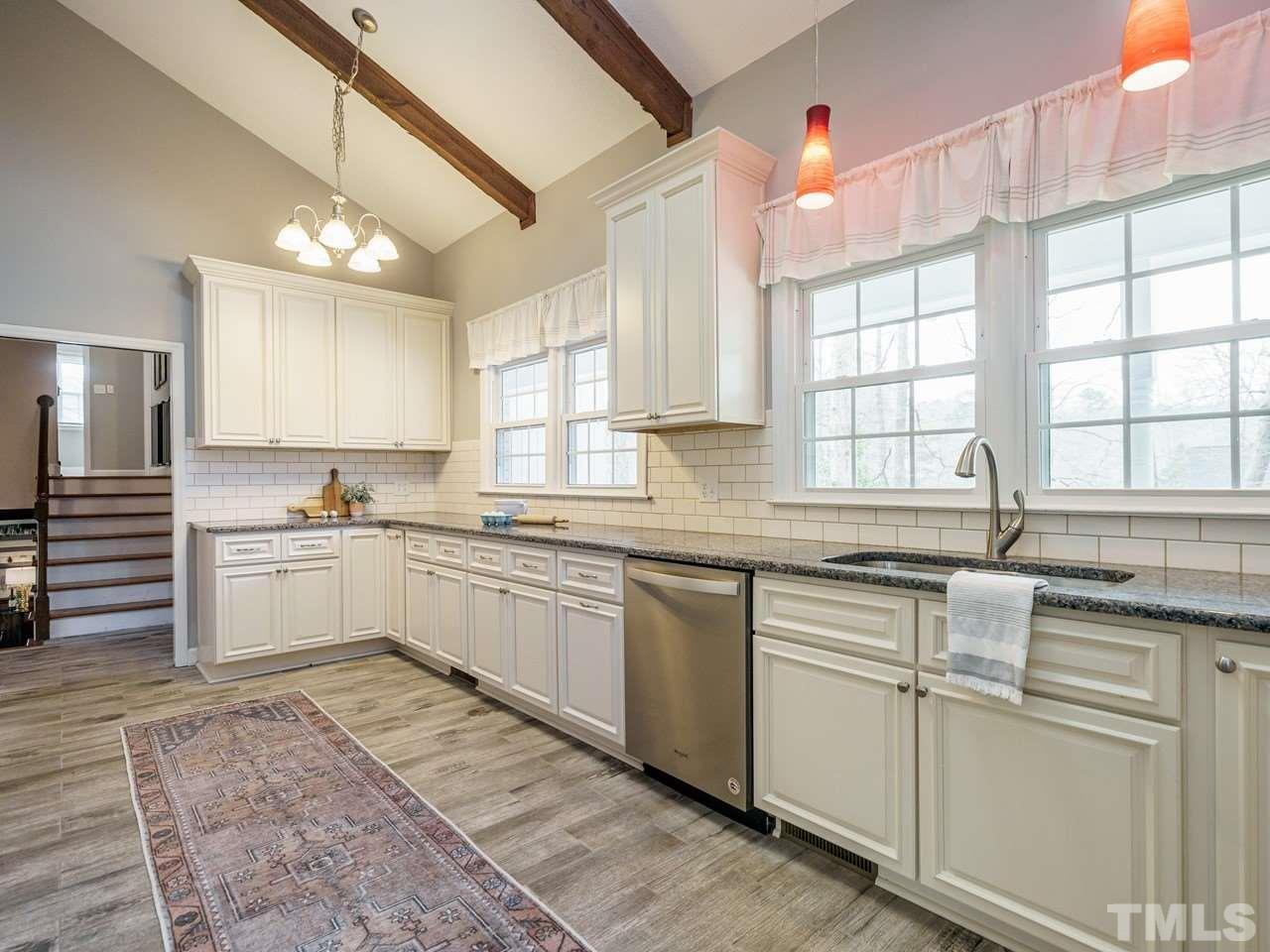 4109 Oak Park Road Raleigh, NC 27612 - Photo 7 of 28 a large white kitchen with granite countertop a sink window and cabinets