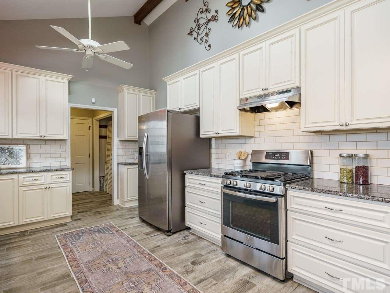 4109 Oak Park Road Raleigh, NC 27612 - Photo 9 of 28 a kitchen with a stove a refrigerator and cabinets