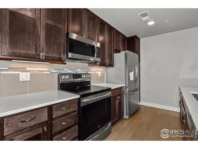 a kitchen with stainless steel appliances wooden cabinets and a sink