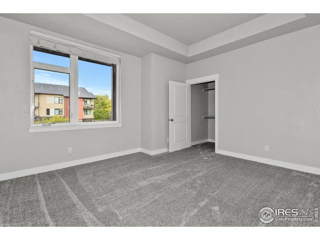 an empty room with windows and closet
